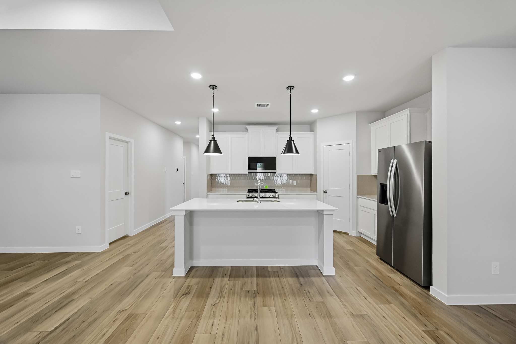 A kitchen with white cabinets.