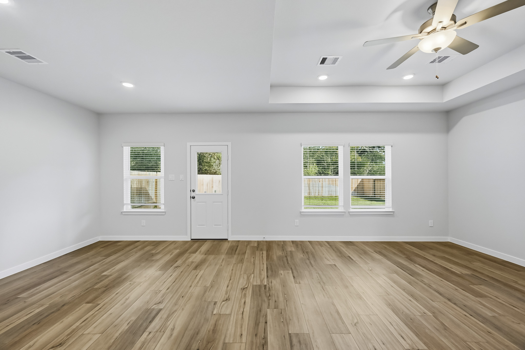 A room with a wood floor and a ceiling fan.