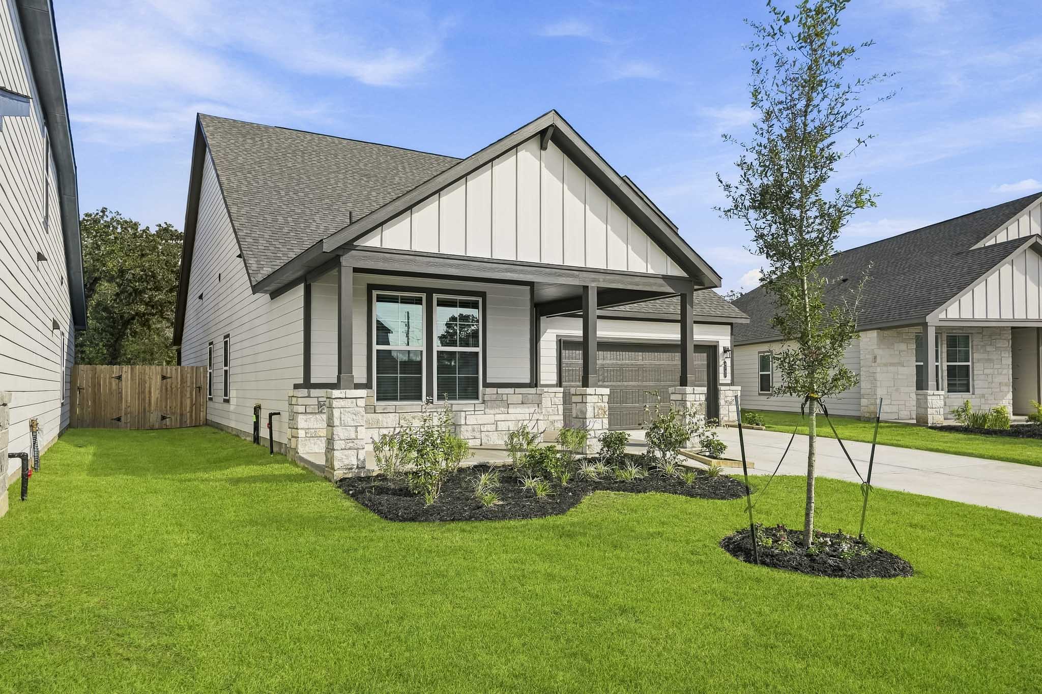 A house with a yard and a tree in the front.