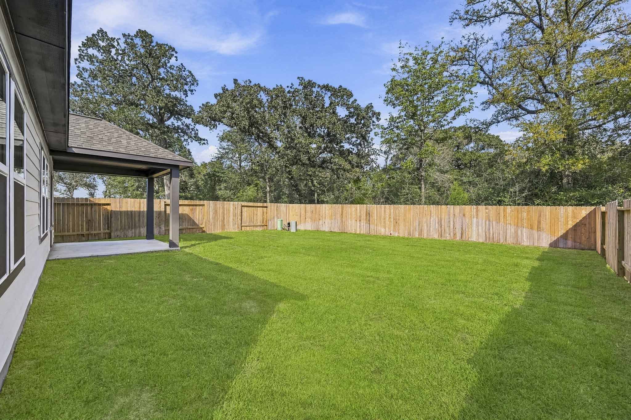 A backyard with a fence and trees.