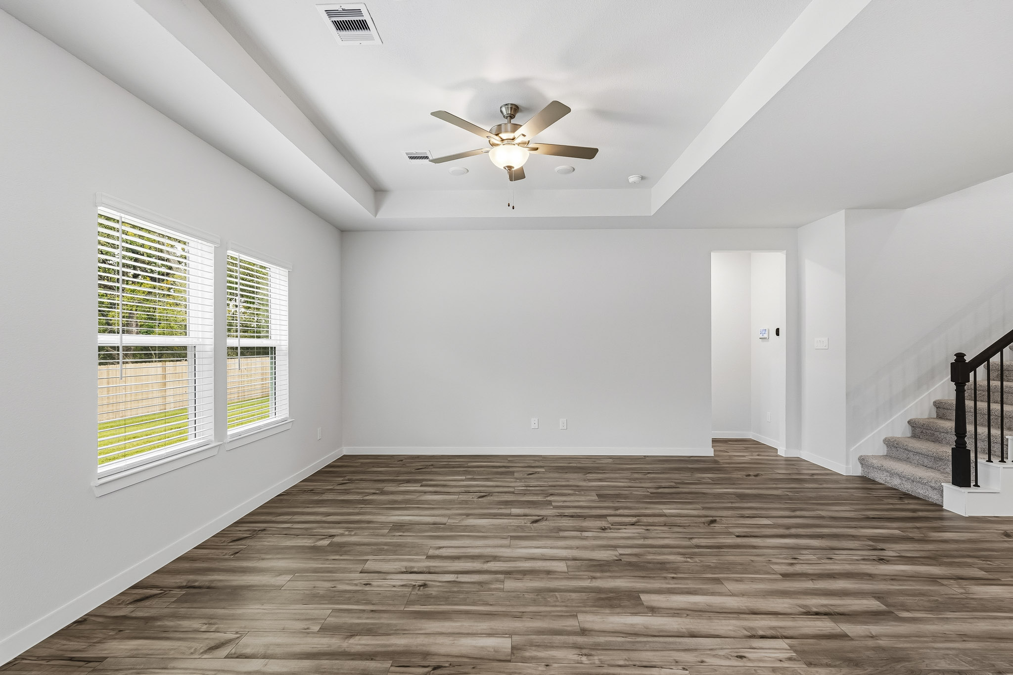 A room with a wood floor and a ceiling fan.