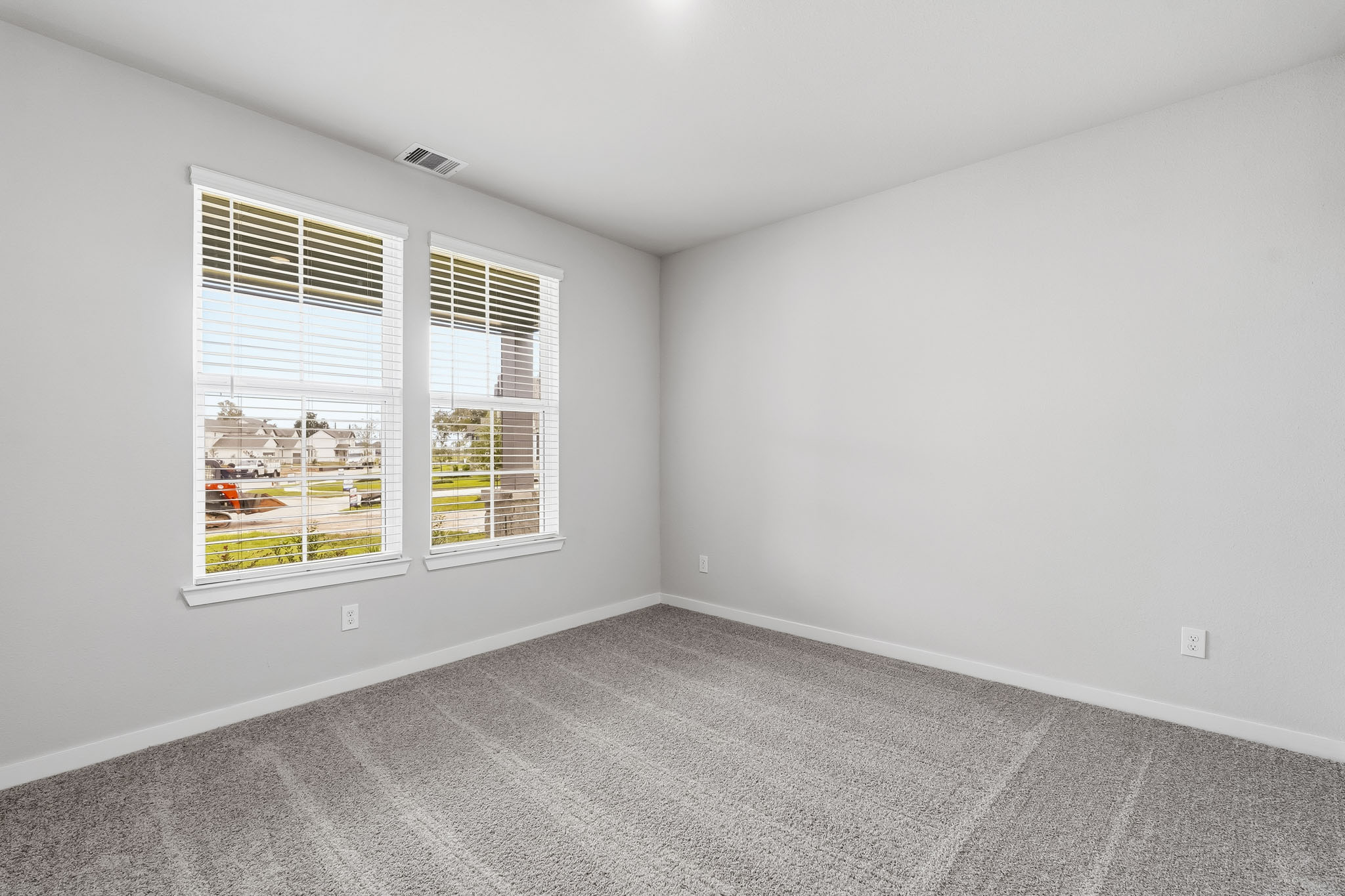A room with a window and a white wall.