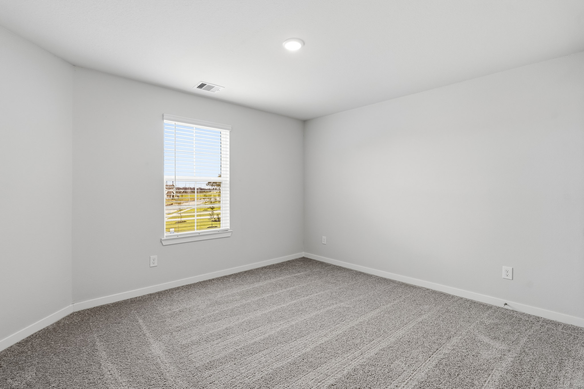 A room with a window and a carpet.