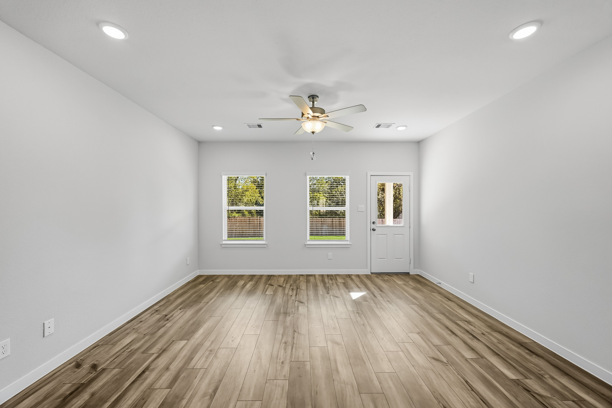A room with a wood floor and a ceiling fan.