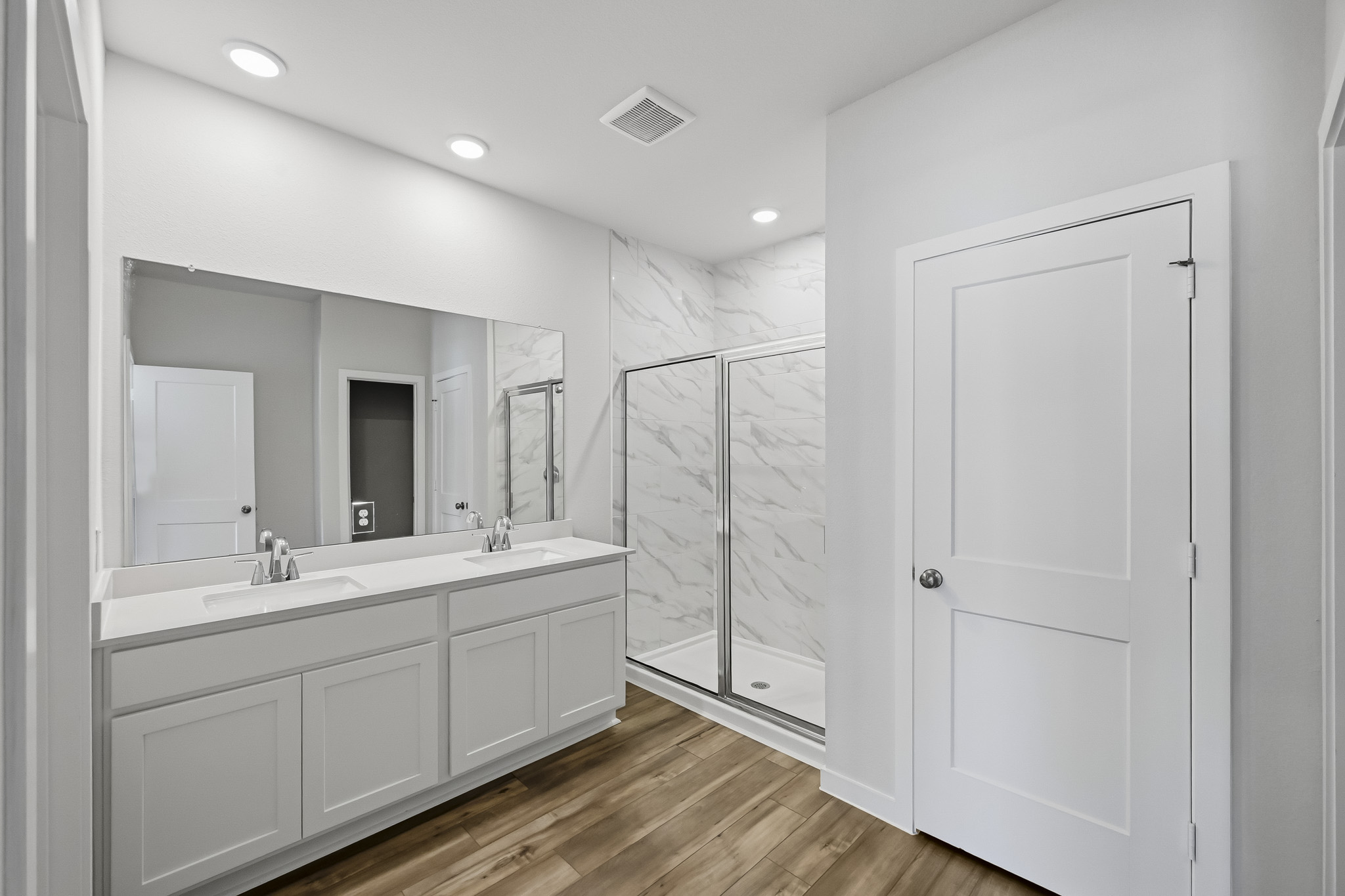A bathroom with white cabinets.