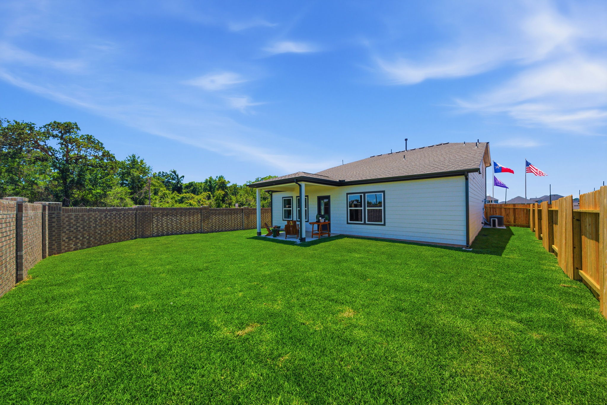 A small house with a fence and grass in front of it.