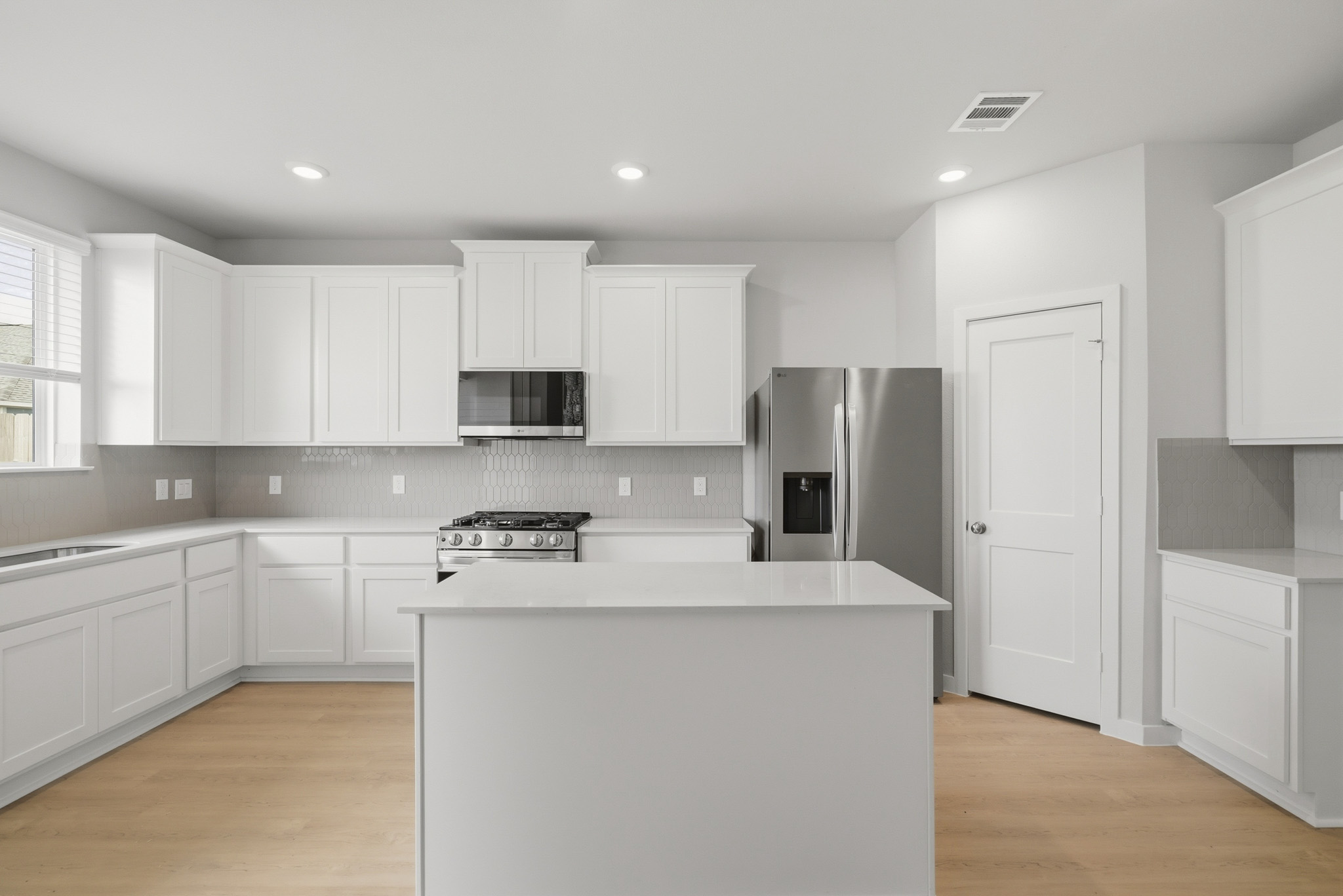 A kitchen with white cabinets.