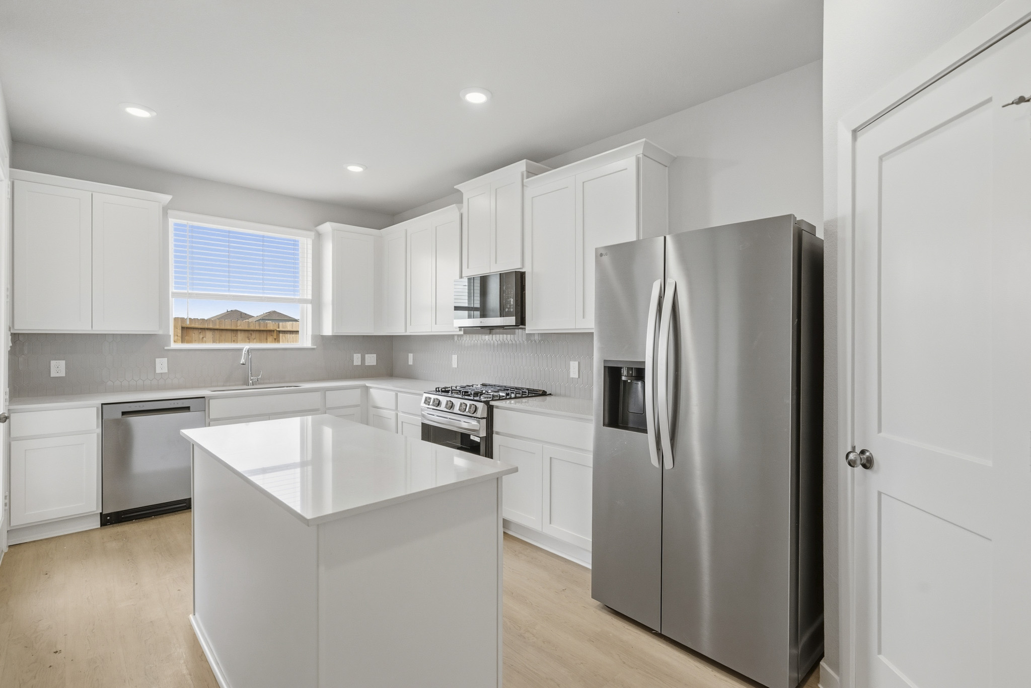 A kitchen with white cabinets.