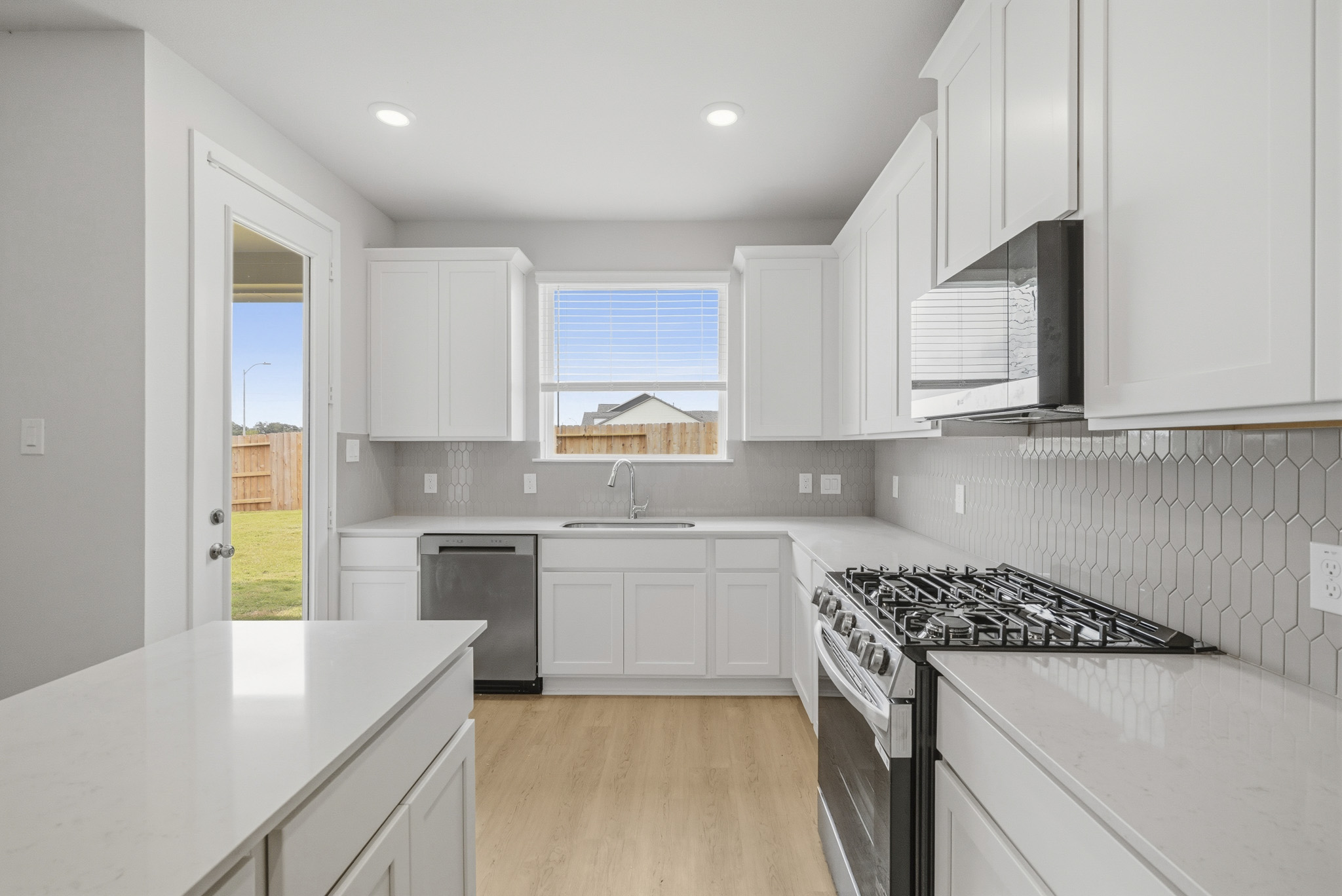 A kitchen with white cabinets.