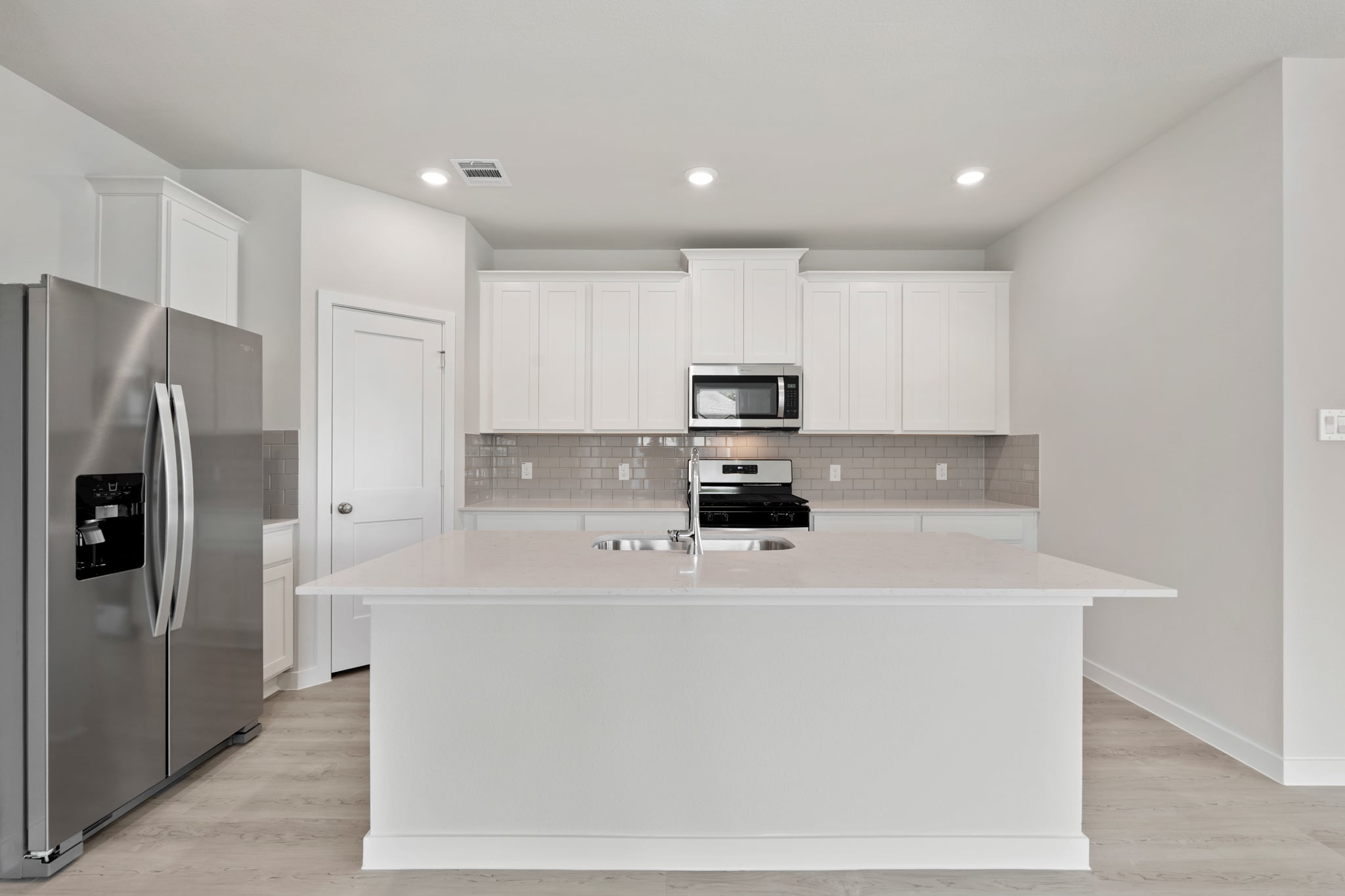 A kitchen with white cabinets.