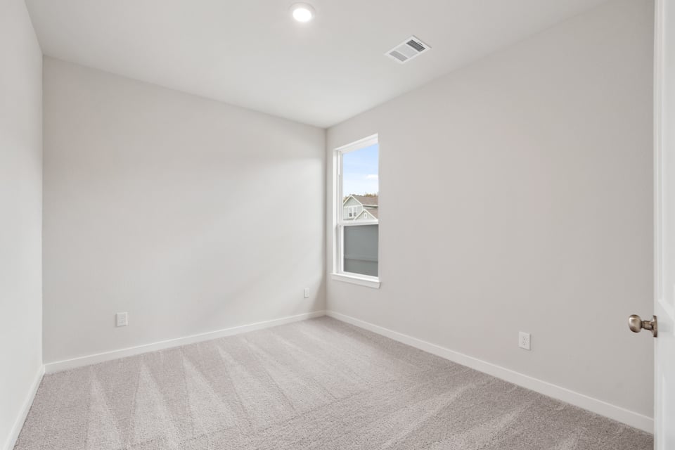 A room with a window and a carpet.