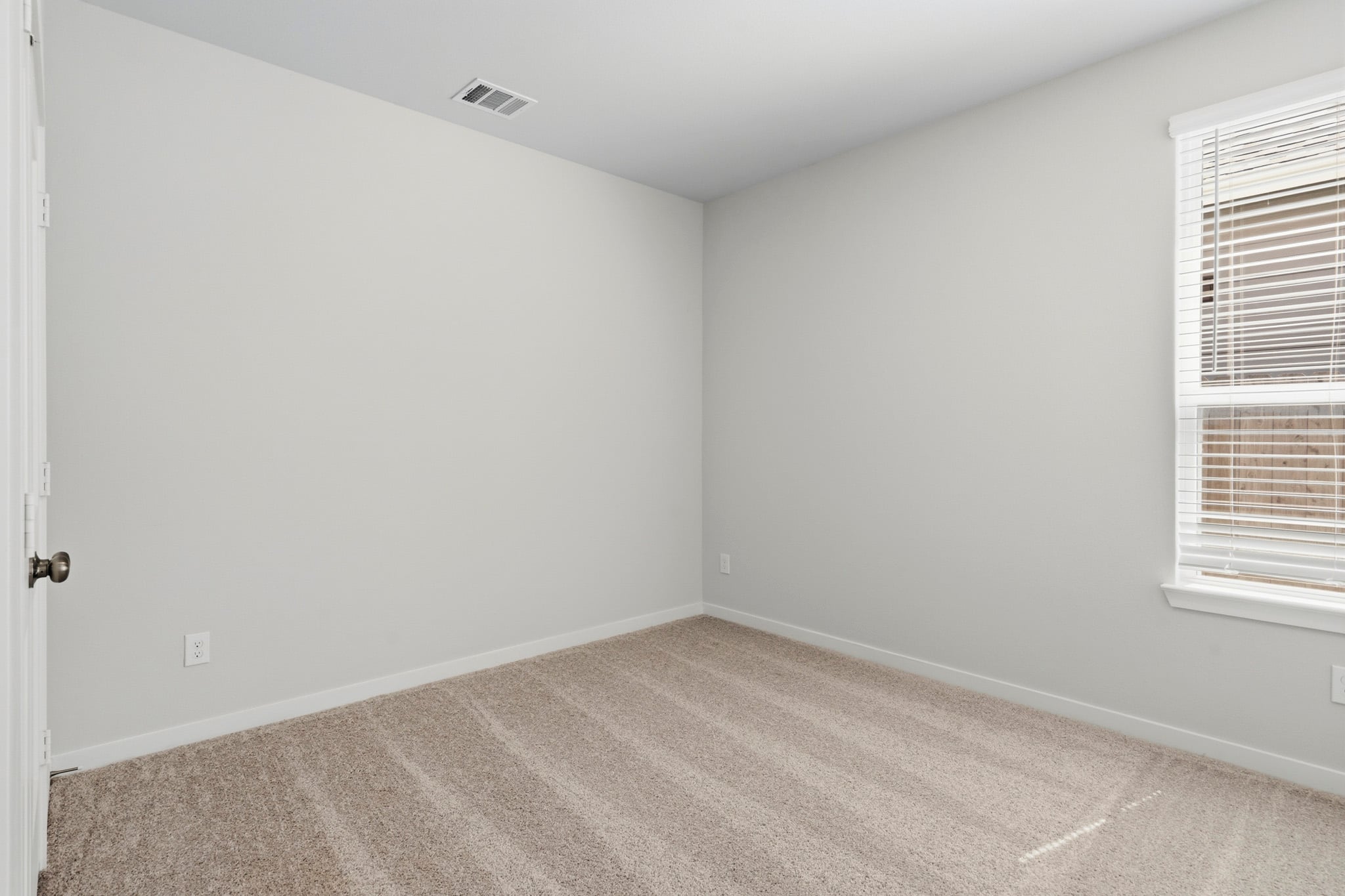 A room with a carpet and a window.