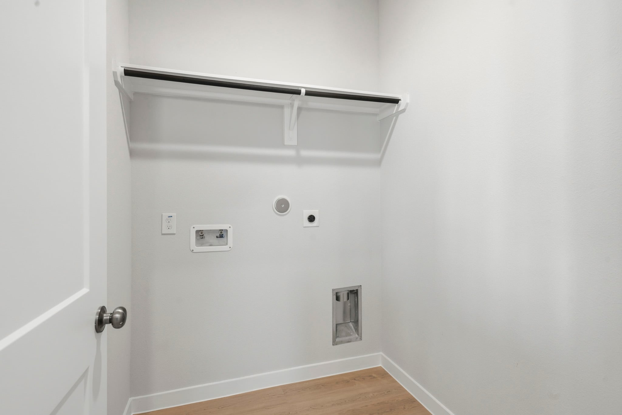 A white wall with a light switch.