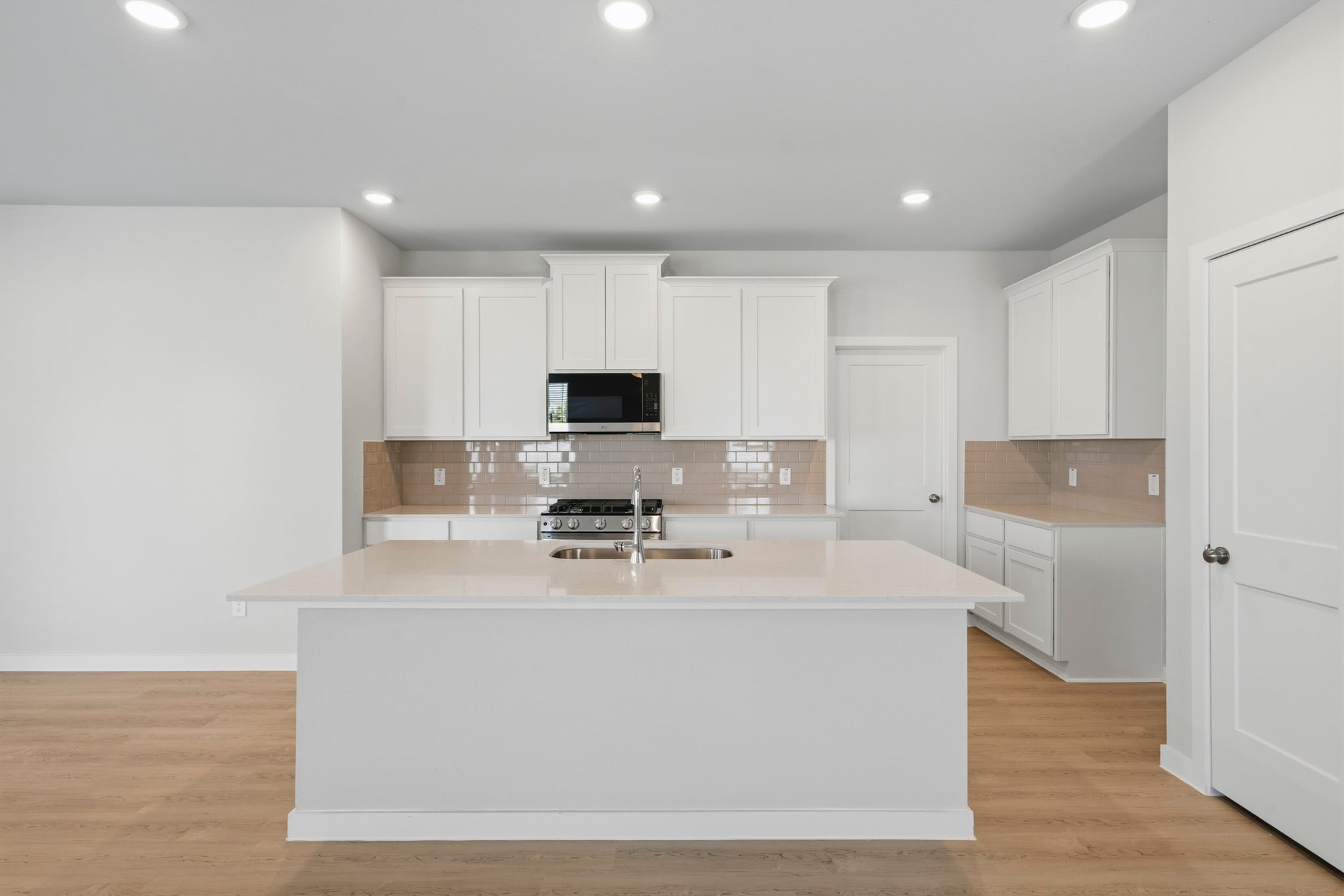 A kitchen with white cabinets.