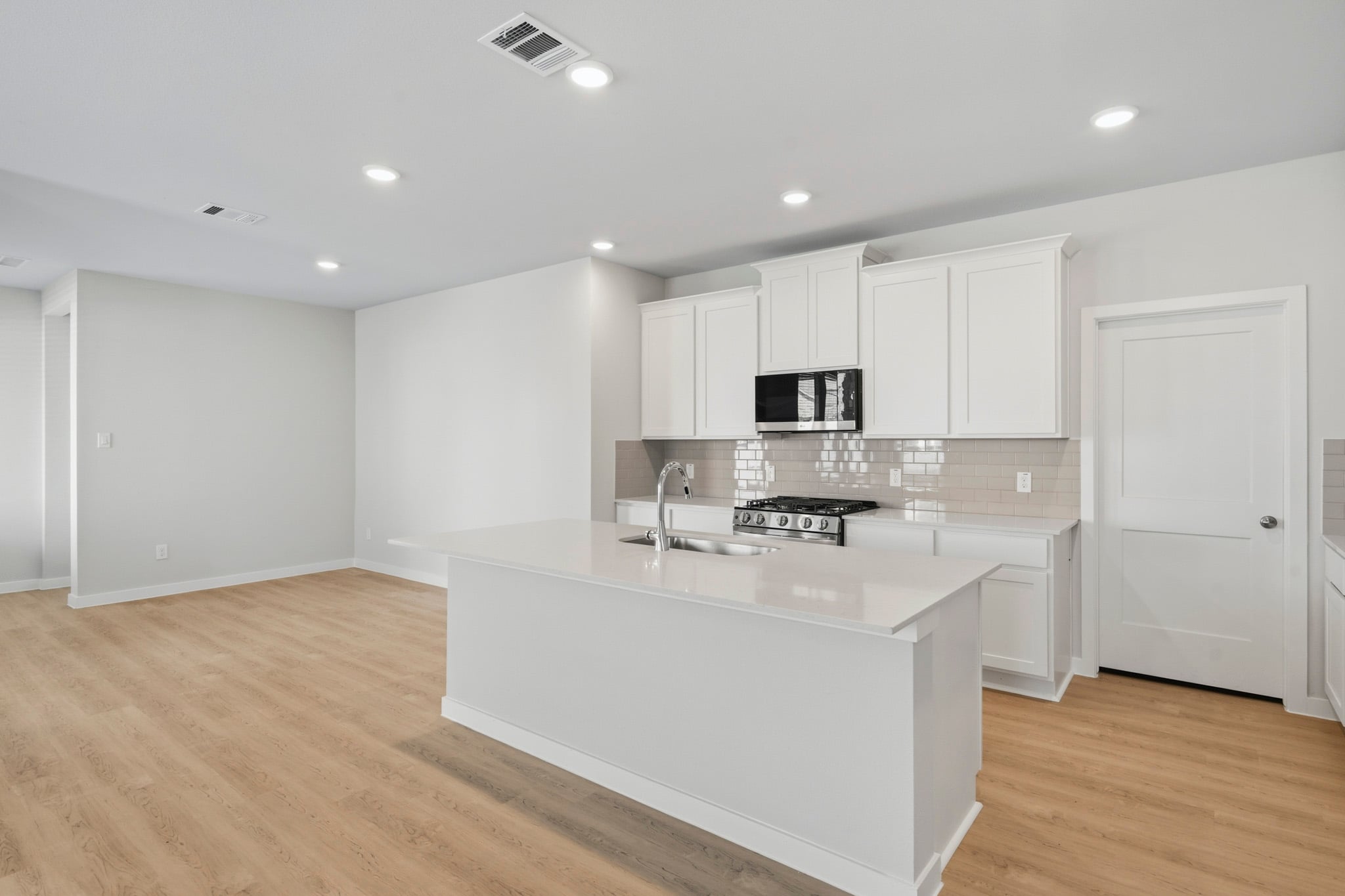 A kitchen with white cabinets.