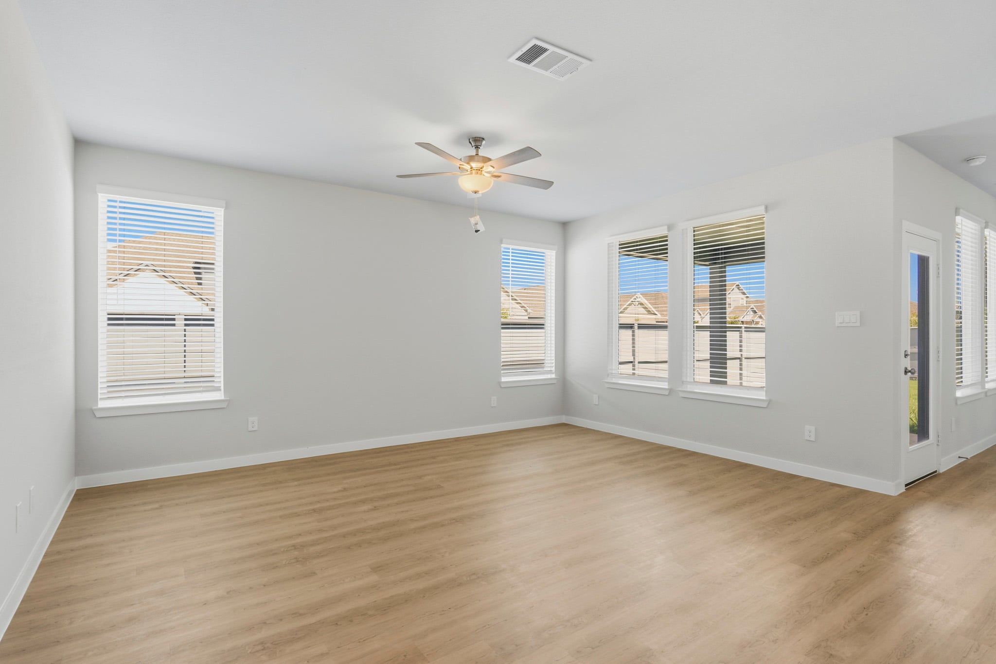 A room with a wood floor and a ceiling fan.