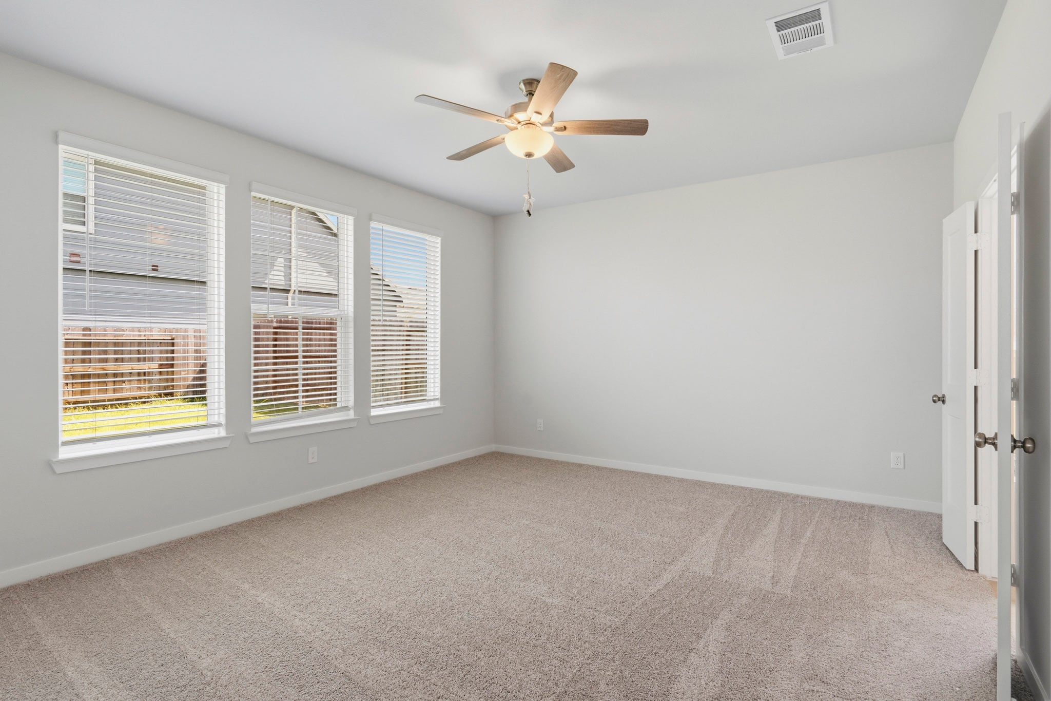 A room with a ceiling fan and a window.