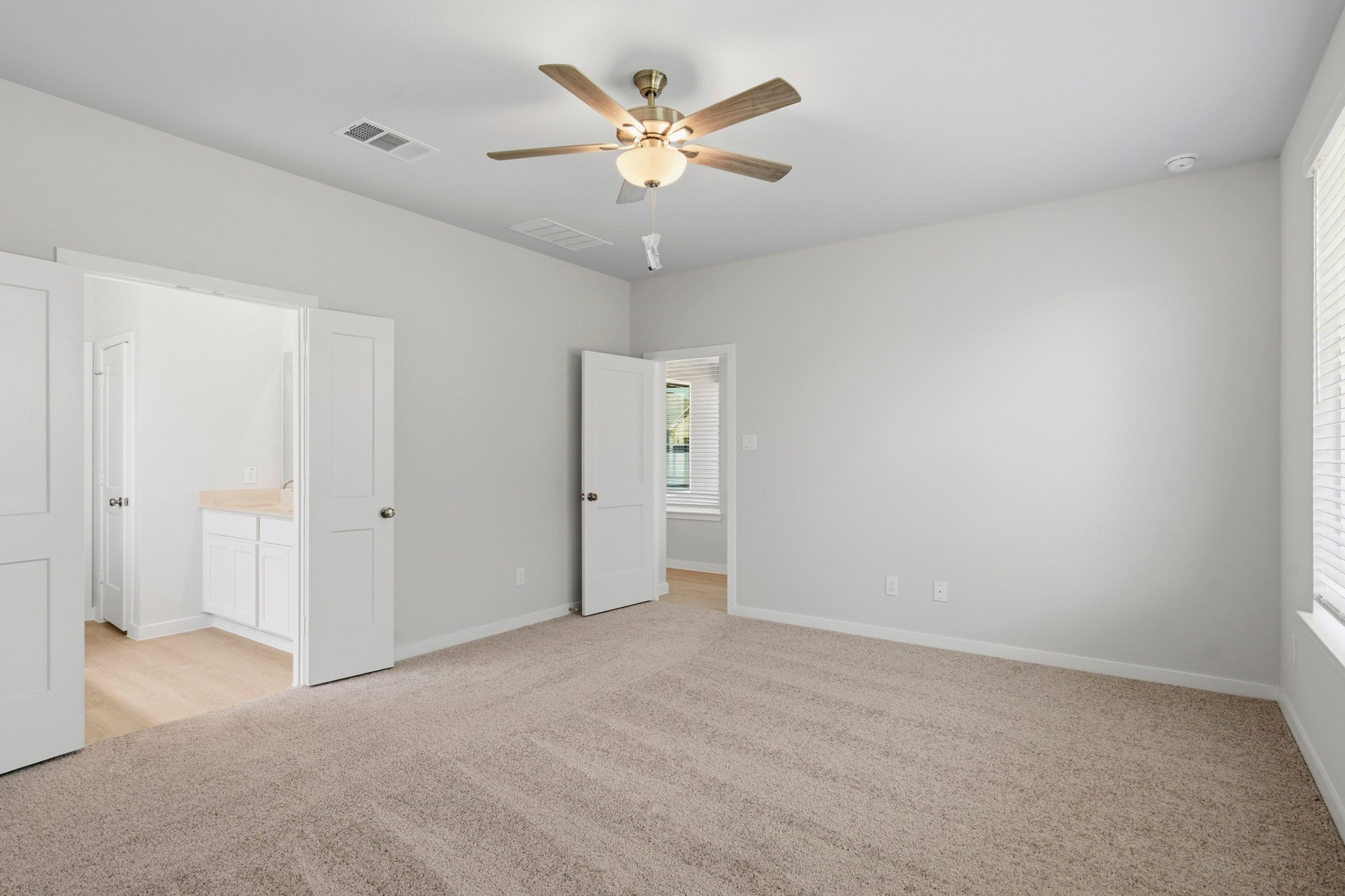 A room with white walls and a ceiling fan.