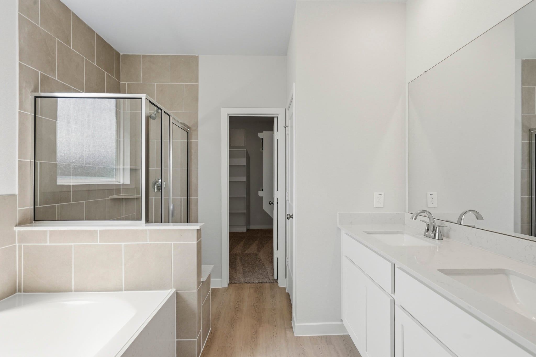 A bathroom with a tub sink and mirror.