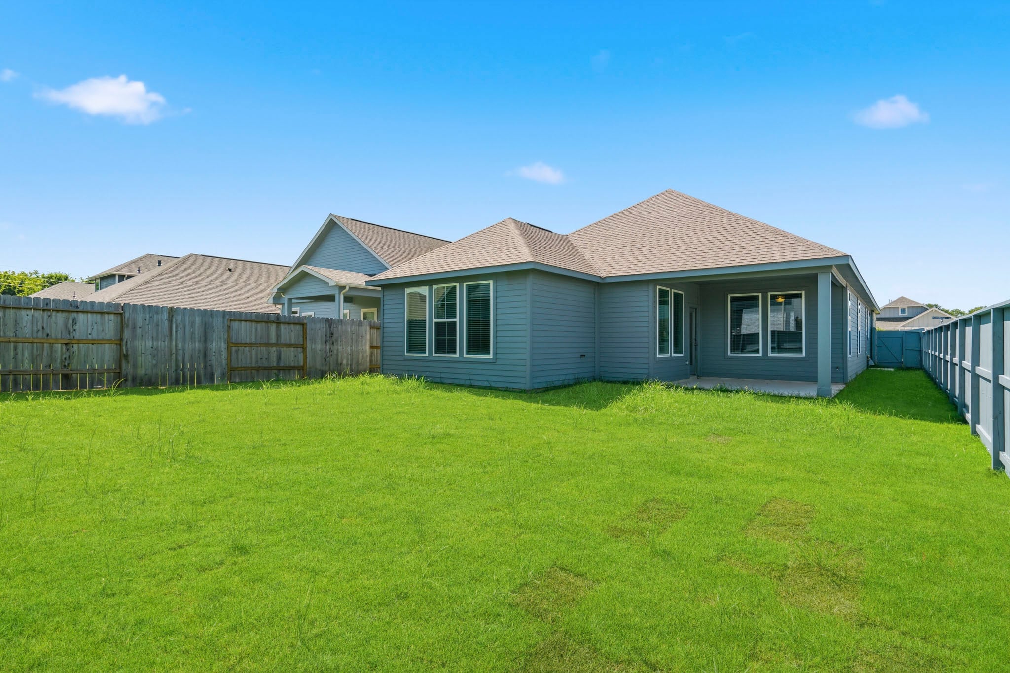 A house with a fence around it with Southfork Ranch in the background.