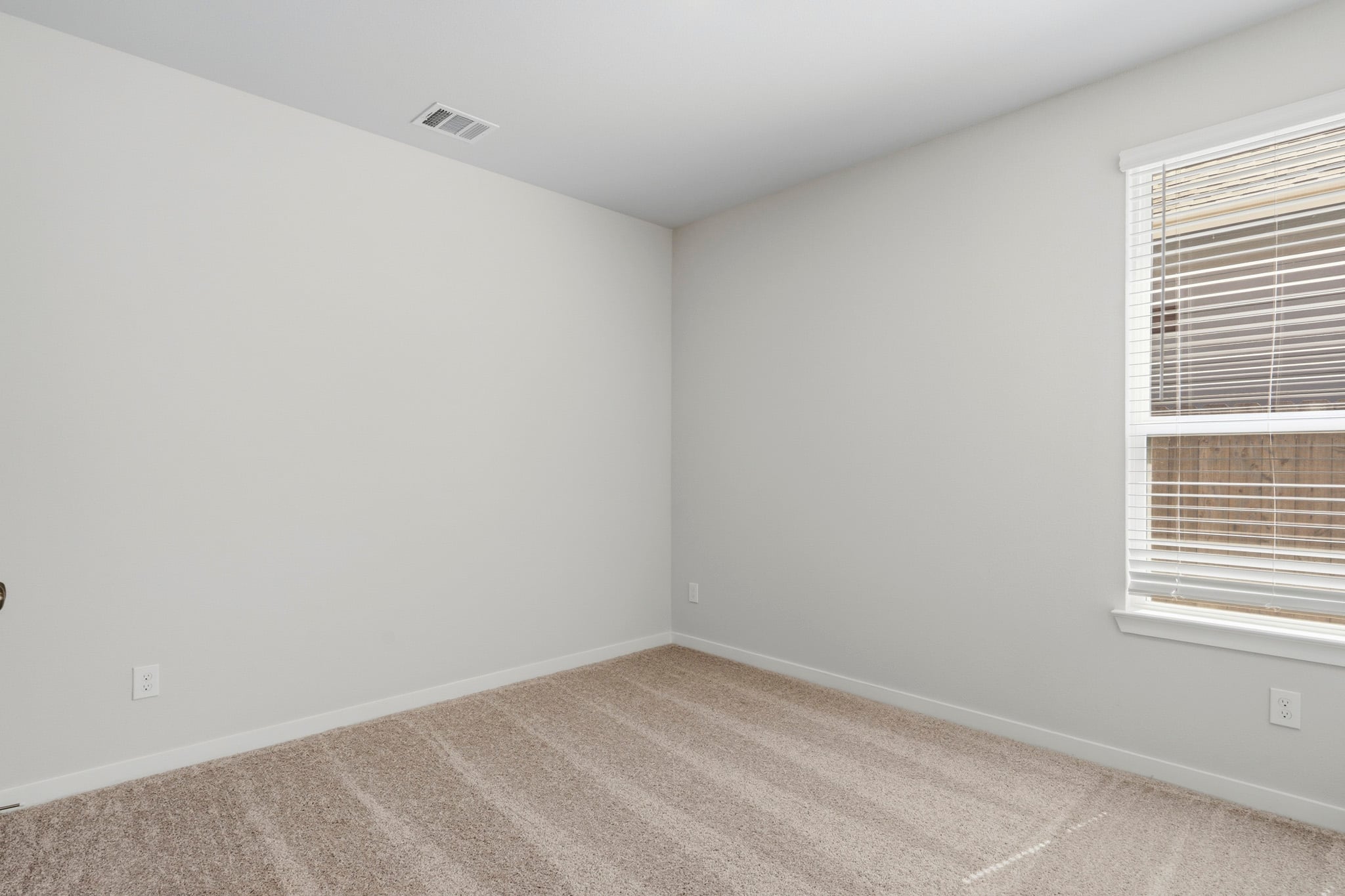 A room with a carpet and a window.