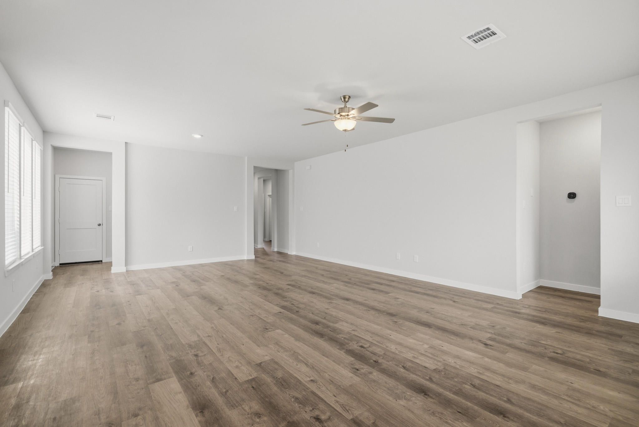 A room with a wood floor and a ceiling fan.