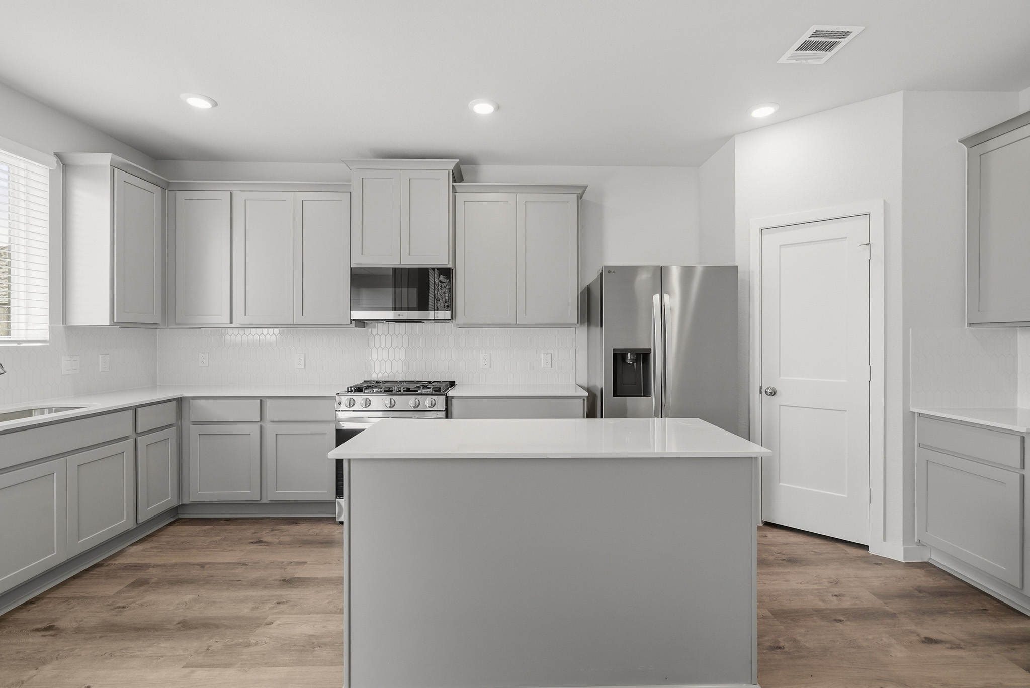 A kitchen with white cabinets.