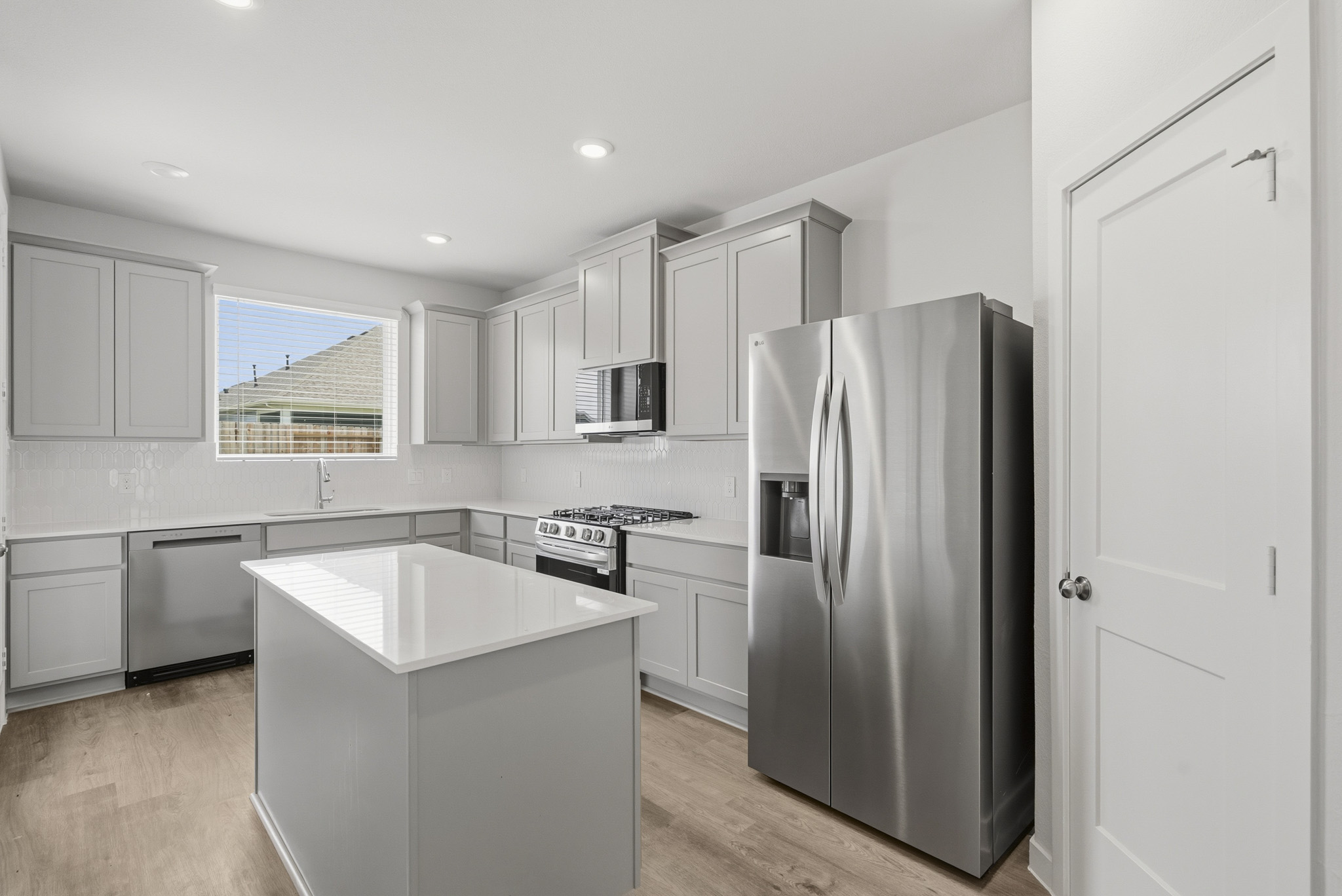 A kitchen with white cabinets.