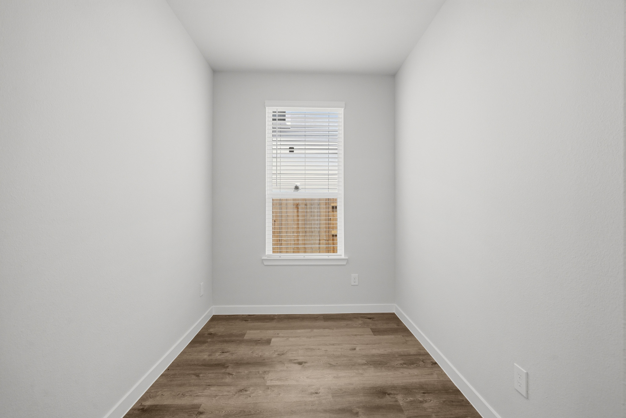A room with a wood floor and a window.