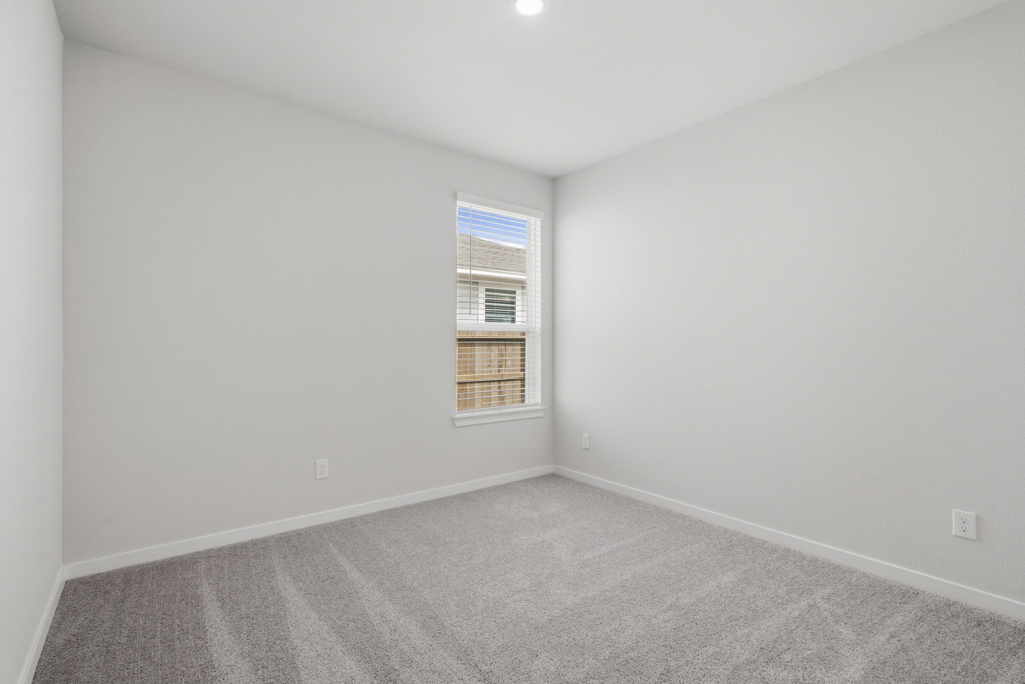 A room with a window and carpet.