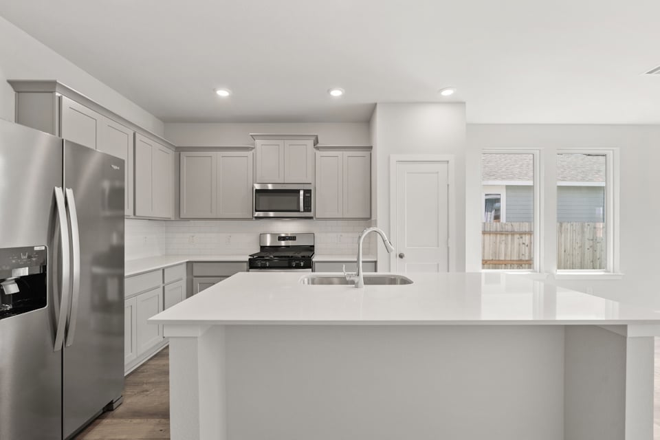 A kitchen with white cabinets.