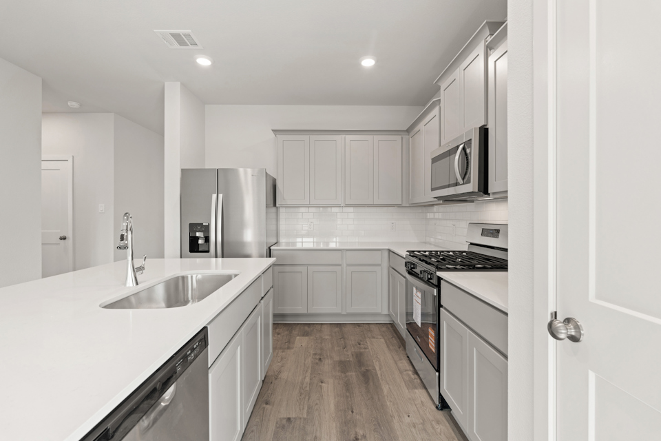 A kitchen with white cabinets.
