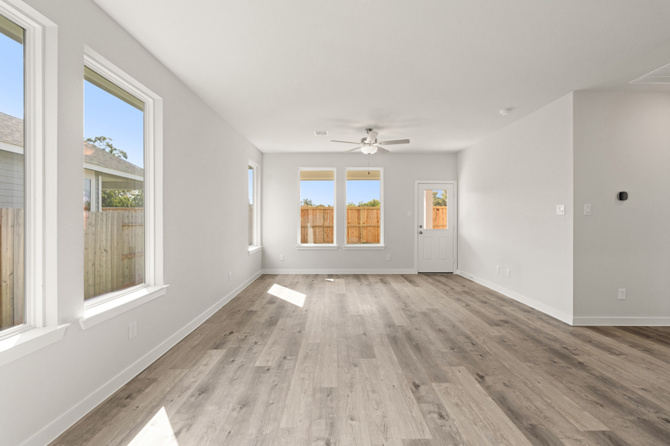 A room with a wood floor and windows.