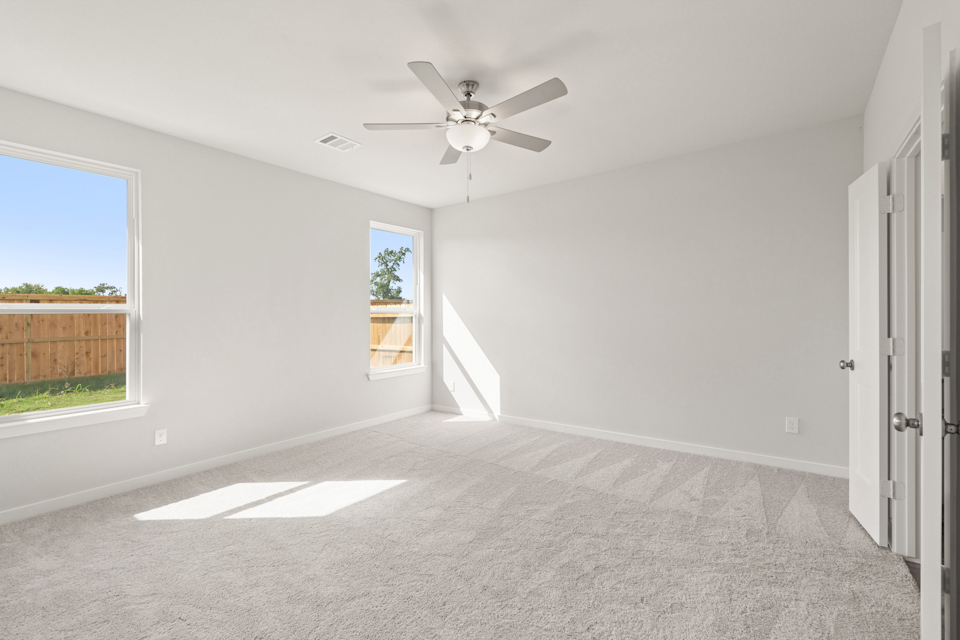 A room with a ceiling fan and a window.
