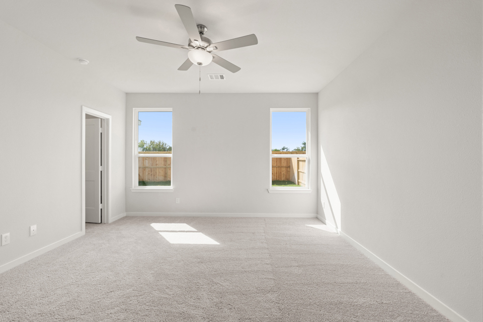 A room with a ceiling fan and a window.