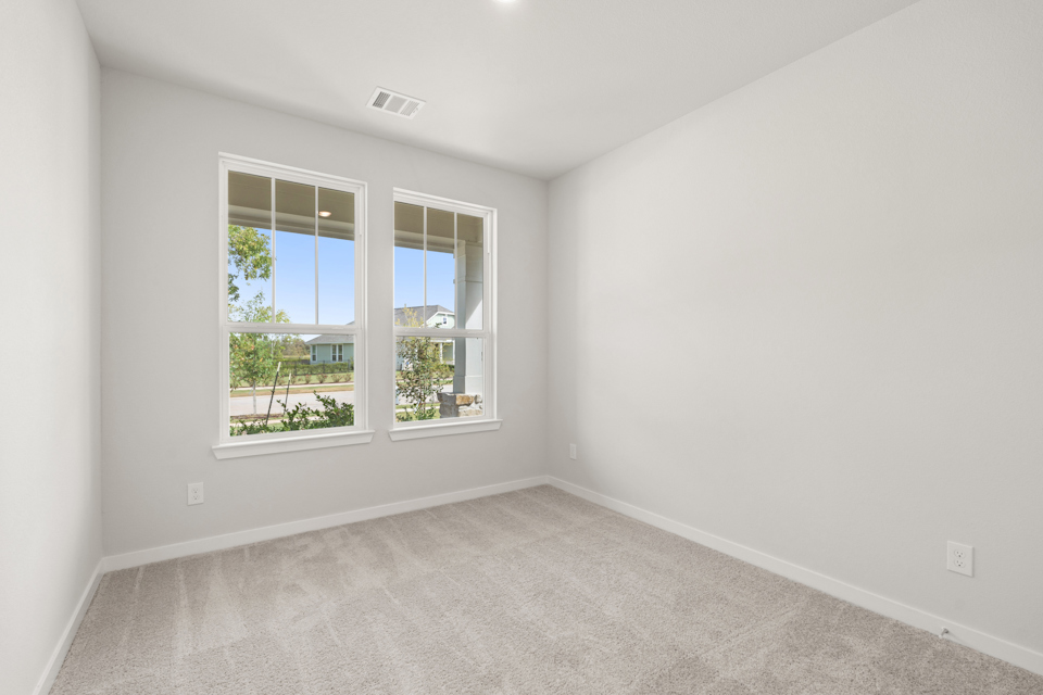 A room with a window and a carpet.