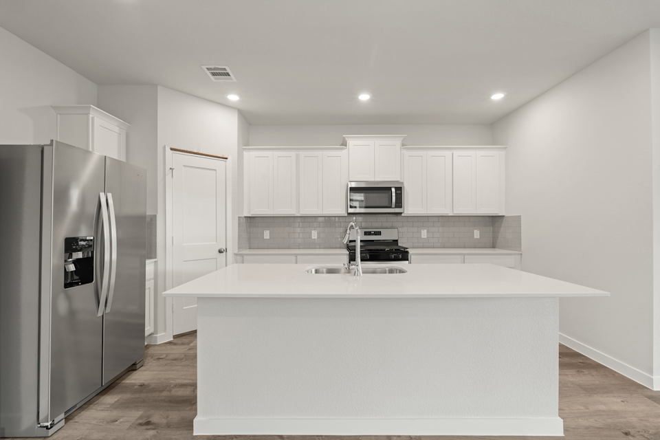 A kitchen with white cabinets.