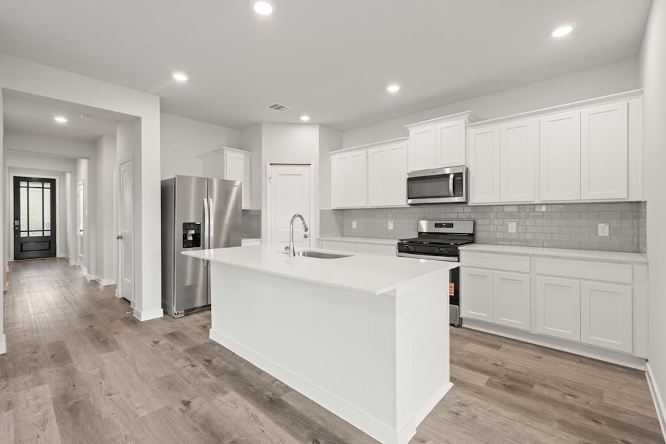 A kitchen with white cabinets.