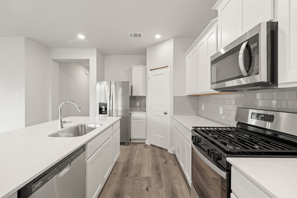 A kitchen with white cabinets.