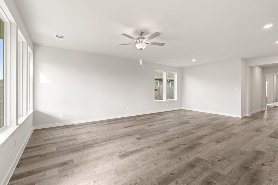 A room with a wood floor and a ceiling fan.