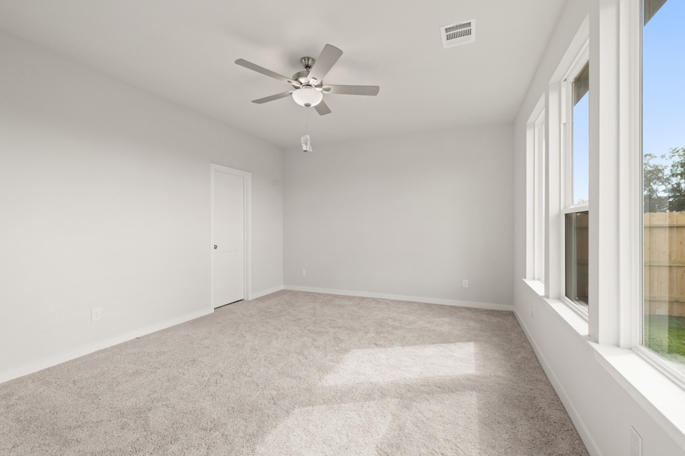 A room with a ceiling fan and a door.