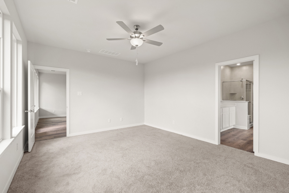 A room with a ceiling fan and a door.