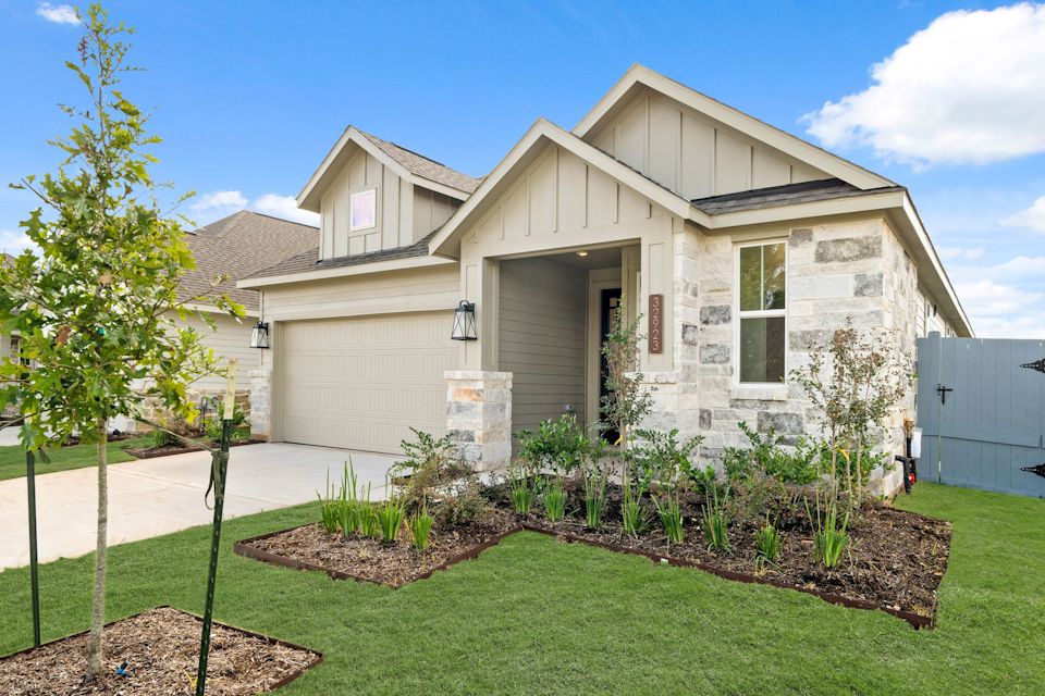 A house with a yard and a tree in the front.