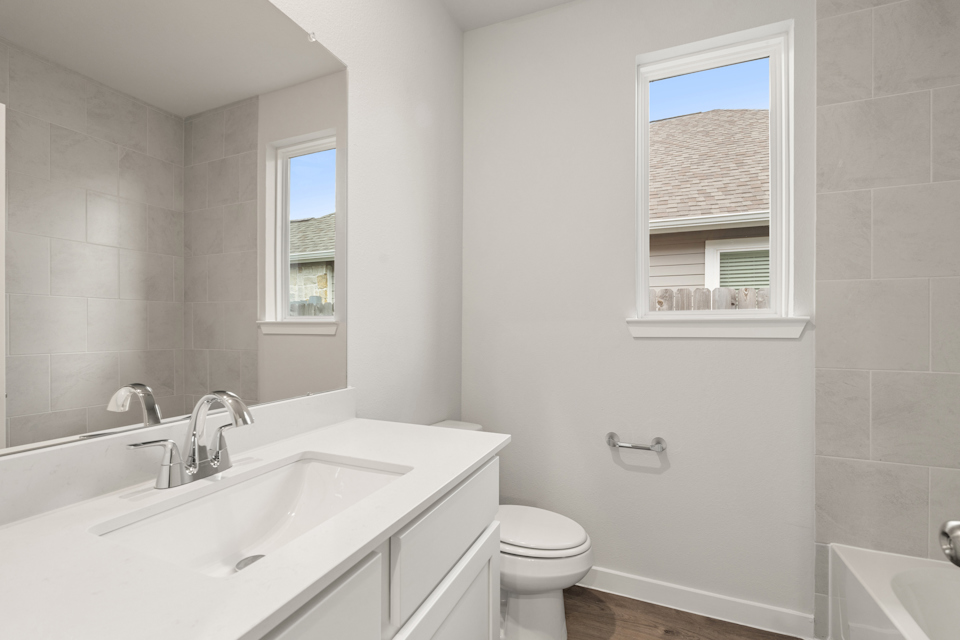 A bathroom with a sink toilet and bathtub.