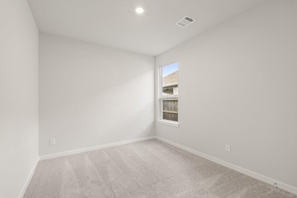 A room with a window and a carpet.