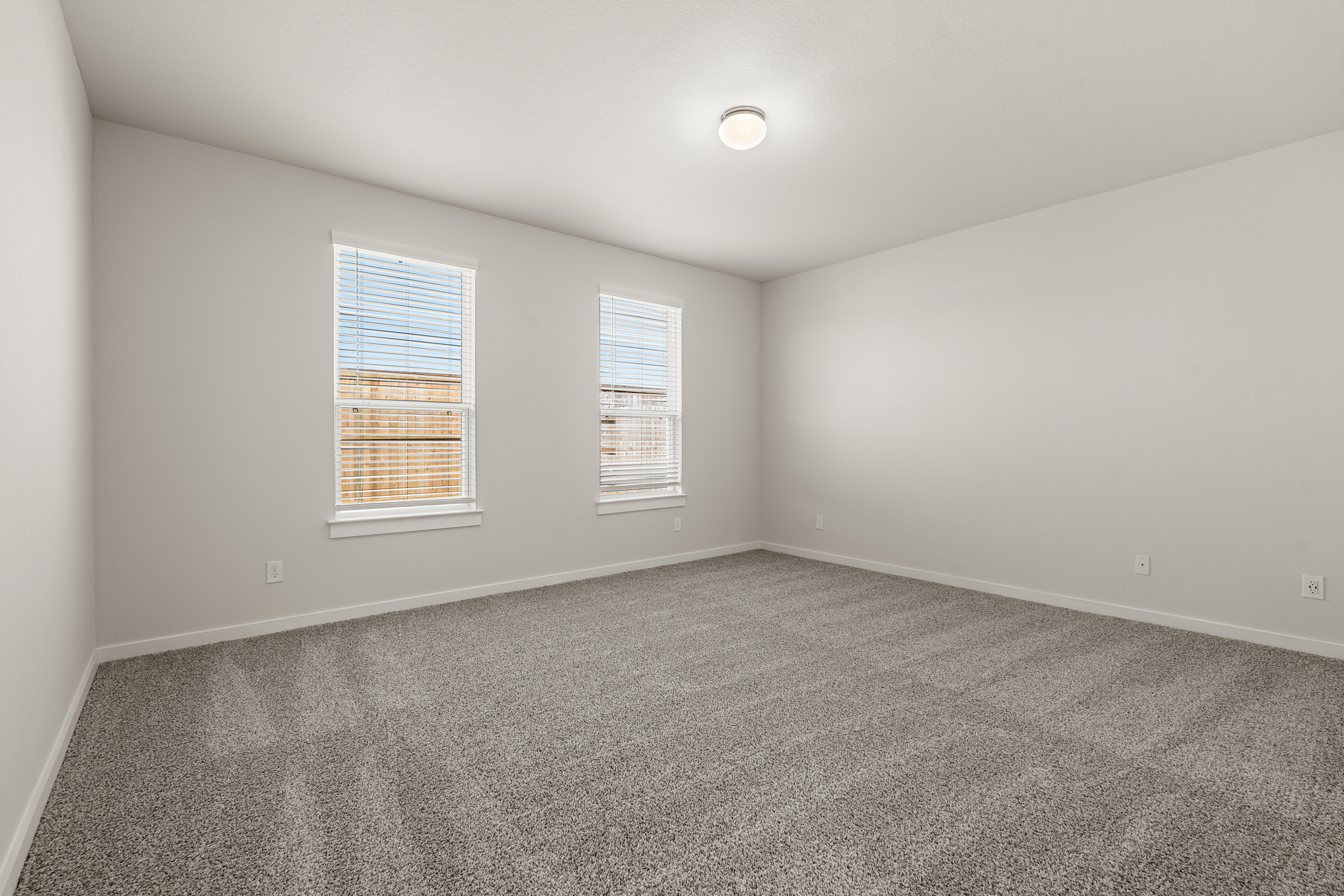 A room with a carpet and a window.