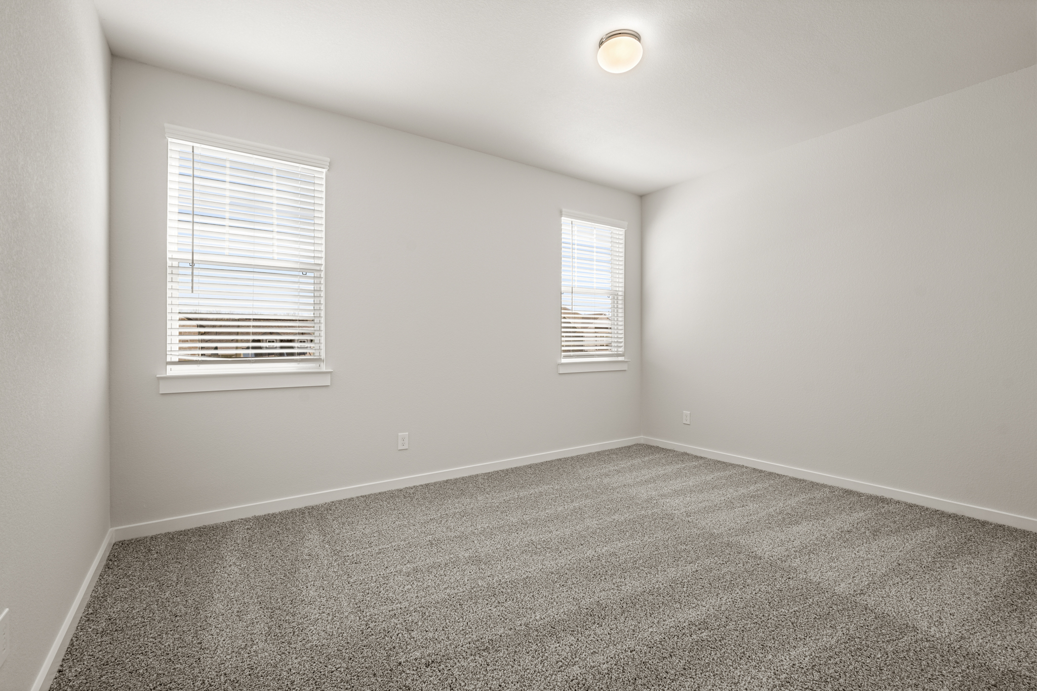 A room with a carpet and a window.