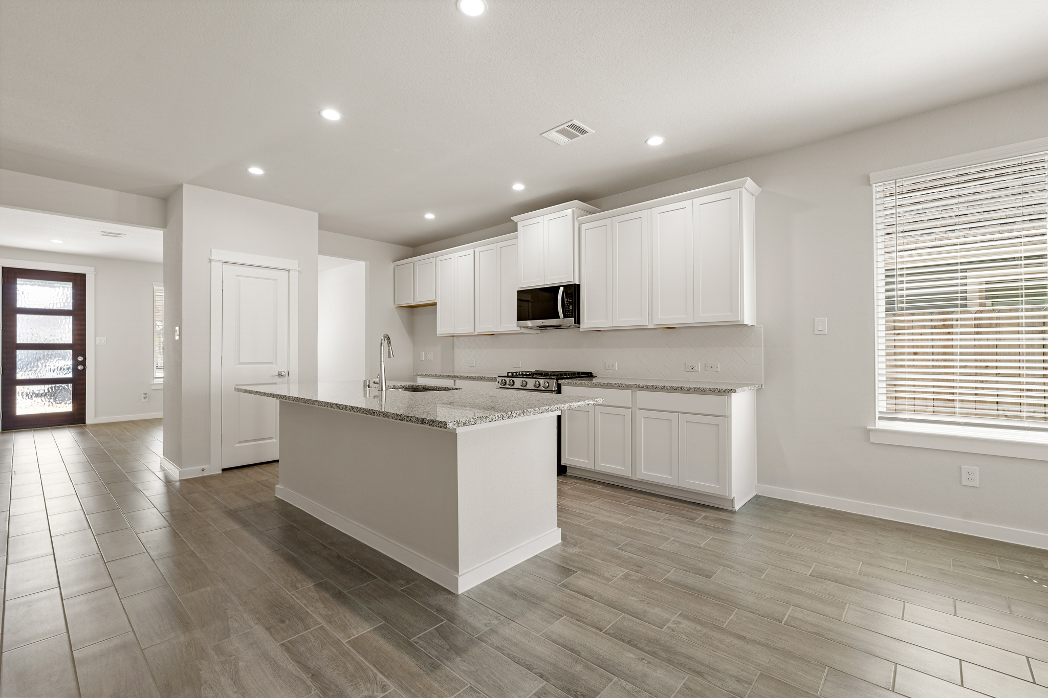 A kitchen with white cabinets.