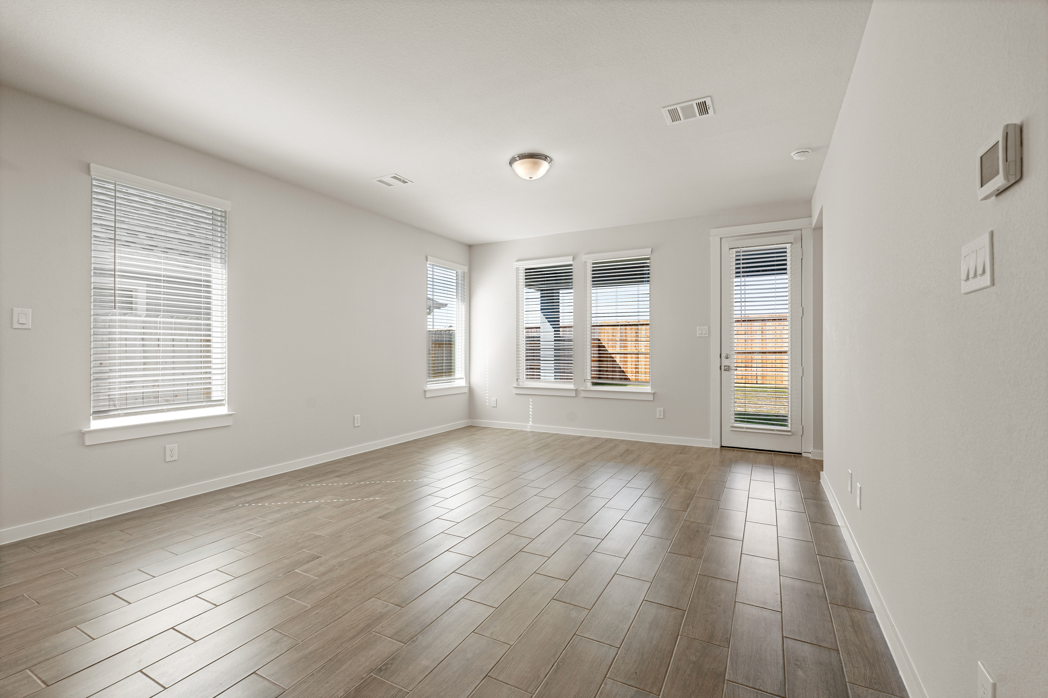 A room with windows and wood floors.