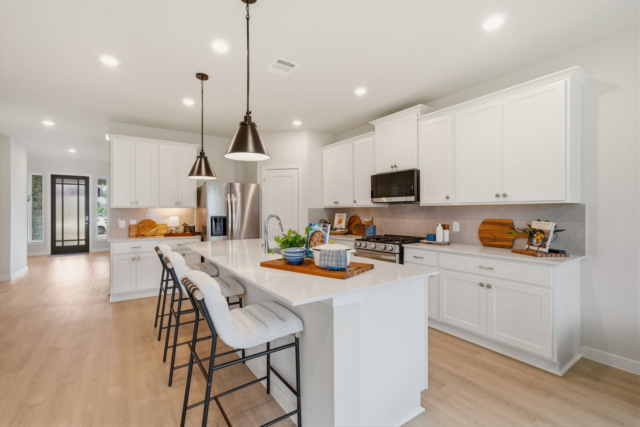 A kitchen with white cabinets.